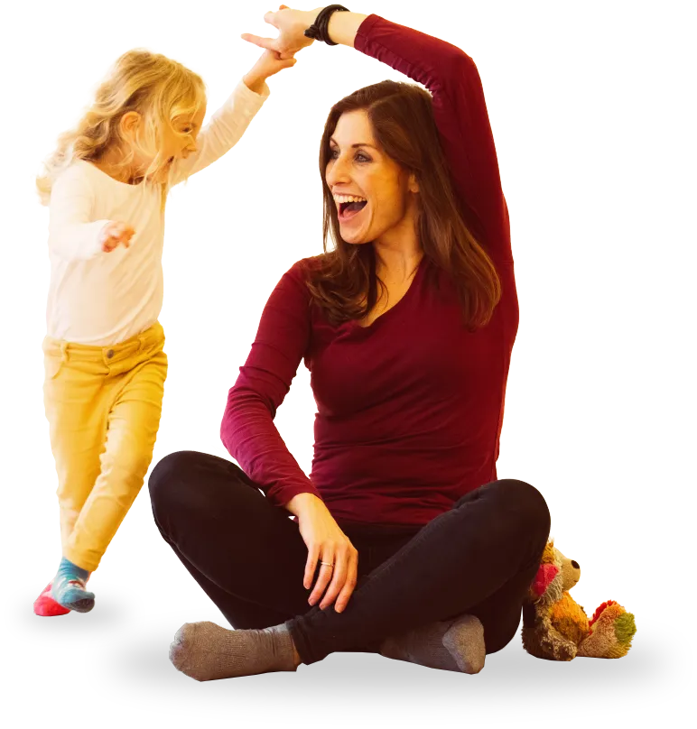Eine Mutter tanzt lachend mit ihrer kleinen Tochter